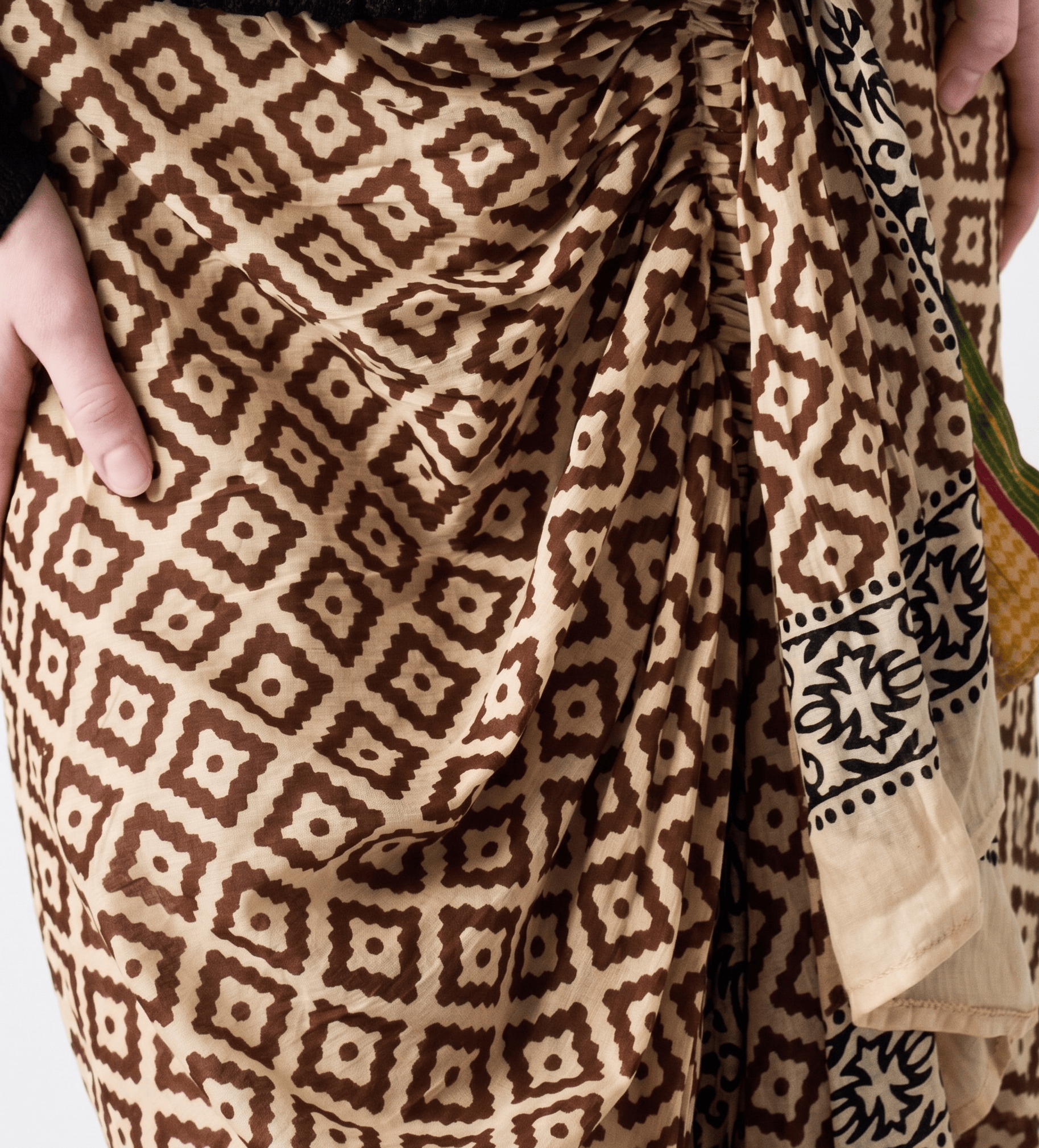 Close-up of a patterned fabric with geometric design in brown and beige tones.